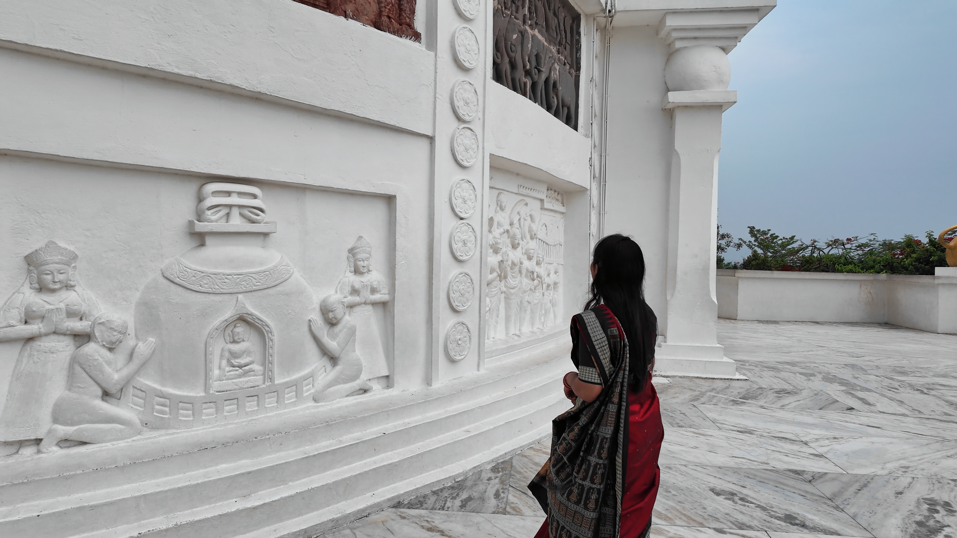Rasmita examining the sculptural panels on the Dhauli Peace Stupa