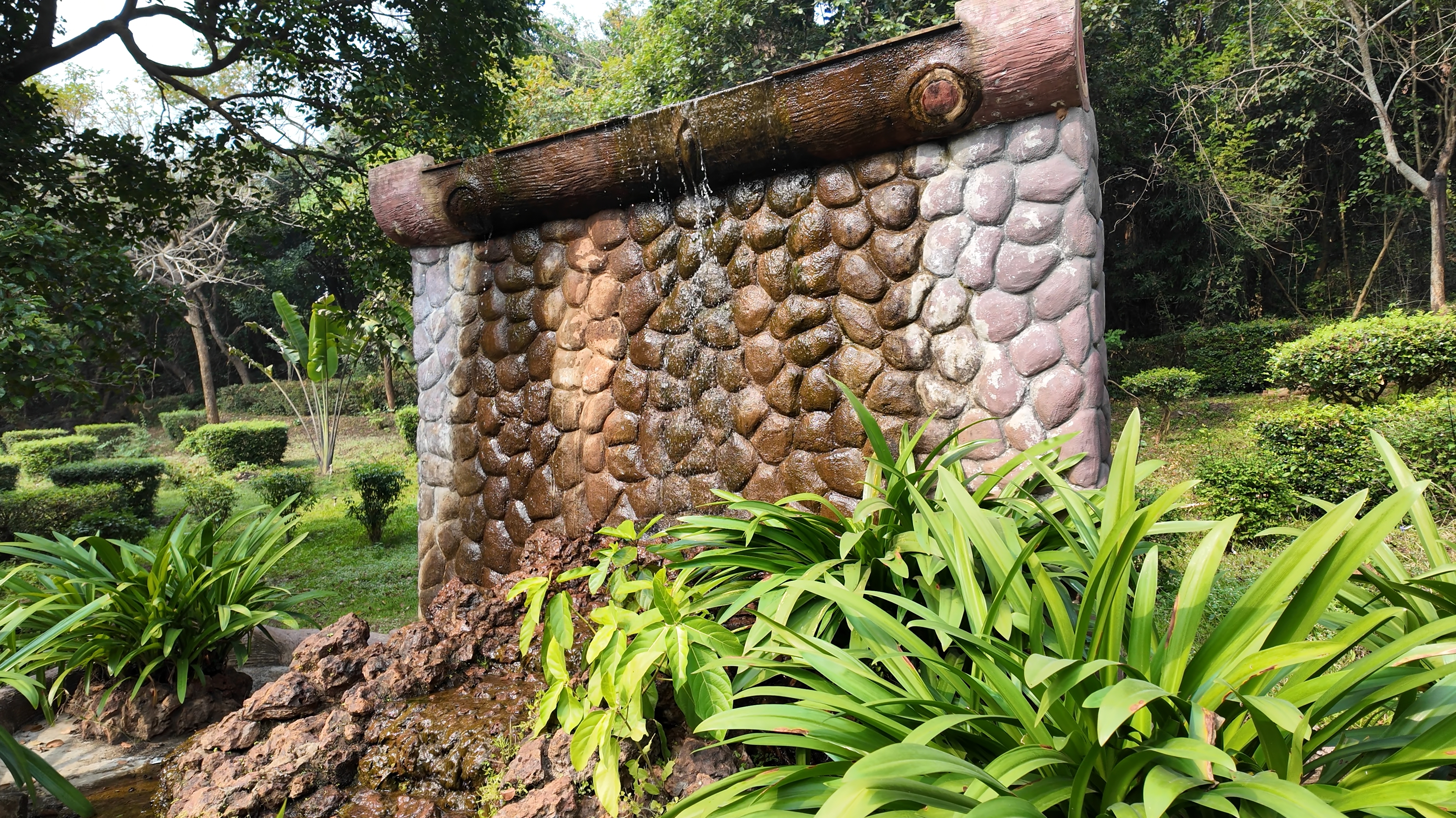 Small waterfall-style fountain with a bridge at the Evolution Garden
